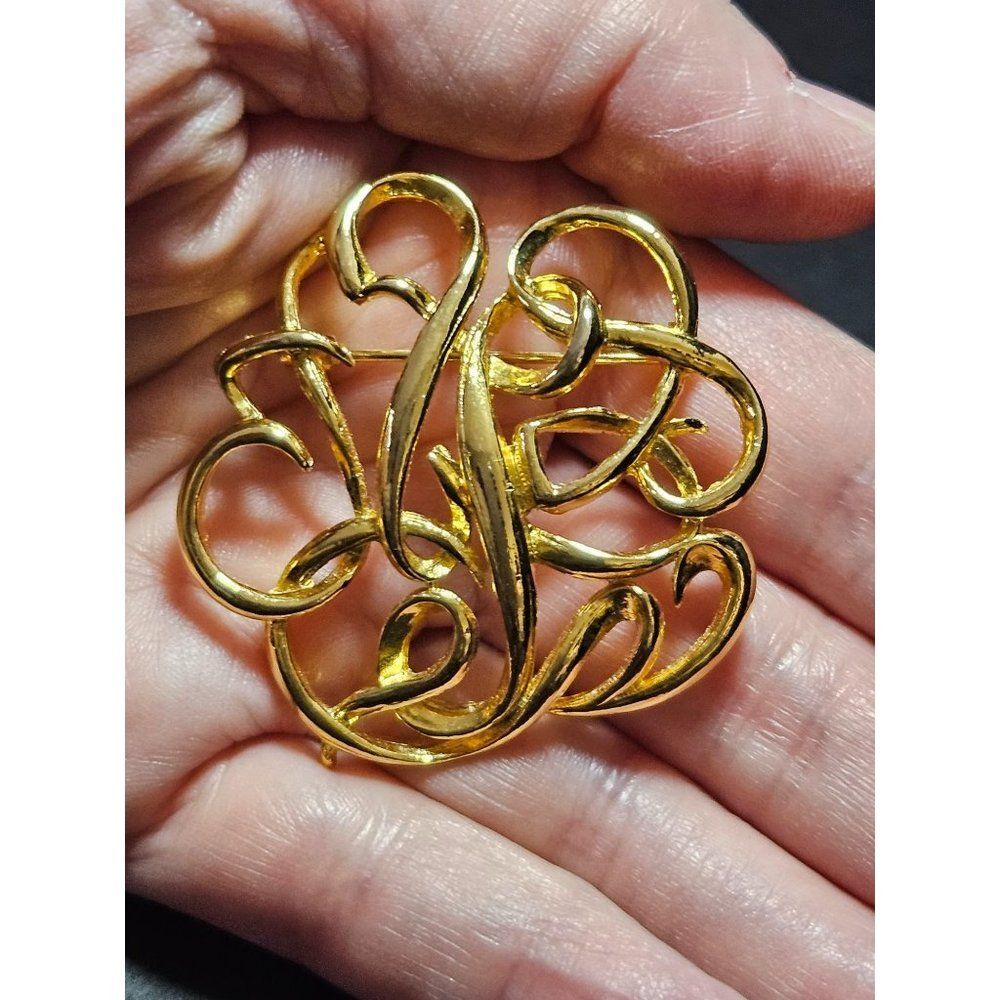 Gold tone vintage round swirly brooch